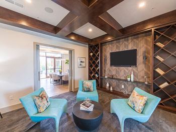 Living area with turquoise chairs and wood accent wall